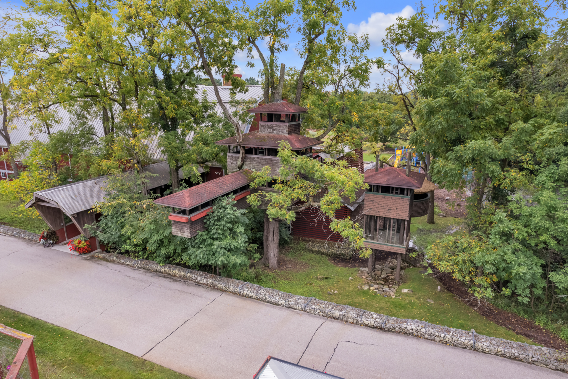 Just past the kid's playground and tucked among a grove of trees is a custom-built treehouse that blends into the wooded landscape with its cedar siding, elevated walkways, and lookout tower.