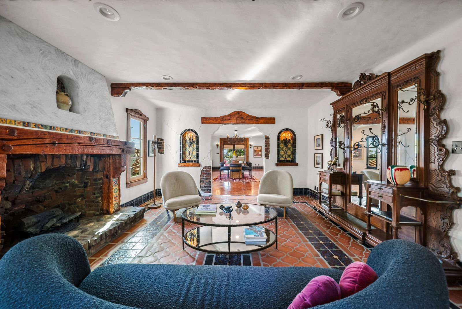 Antique carved cabinetry, reclaimed clinker brick, and arched niches add further layers of craftsmanship, creating a warm gathering space.