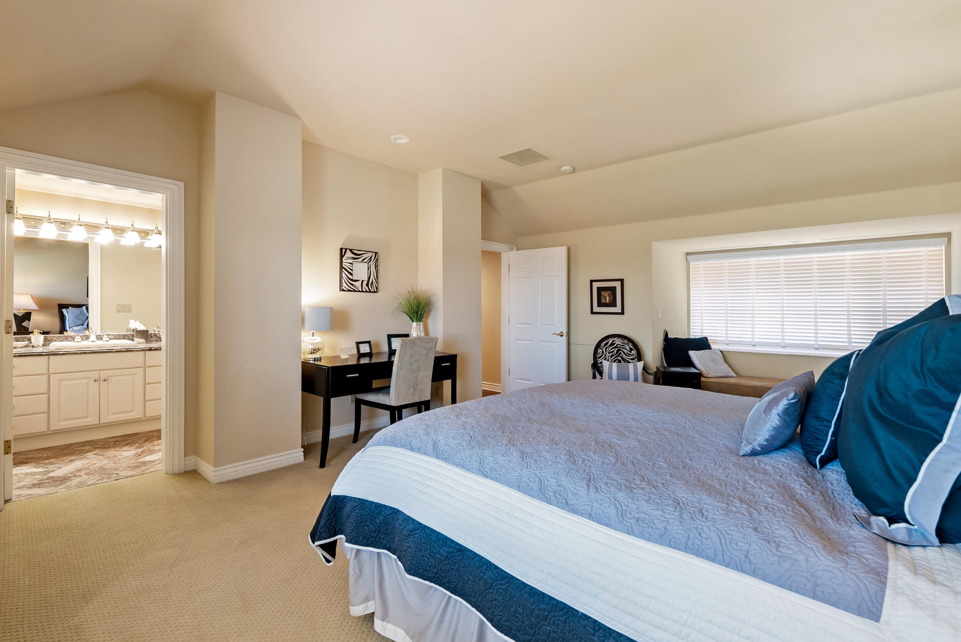 A third medium-sized bedroom follows a longer layout, with a small desk placed into an alcove across from the bed, and next to the en-suite bathroom.