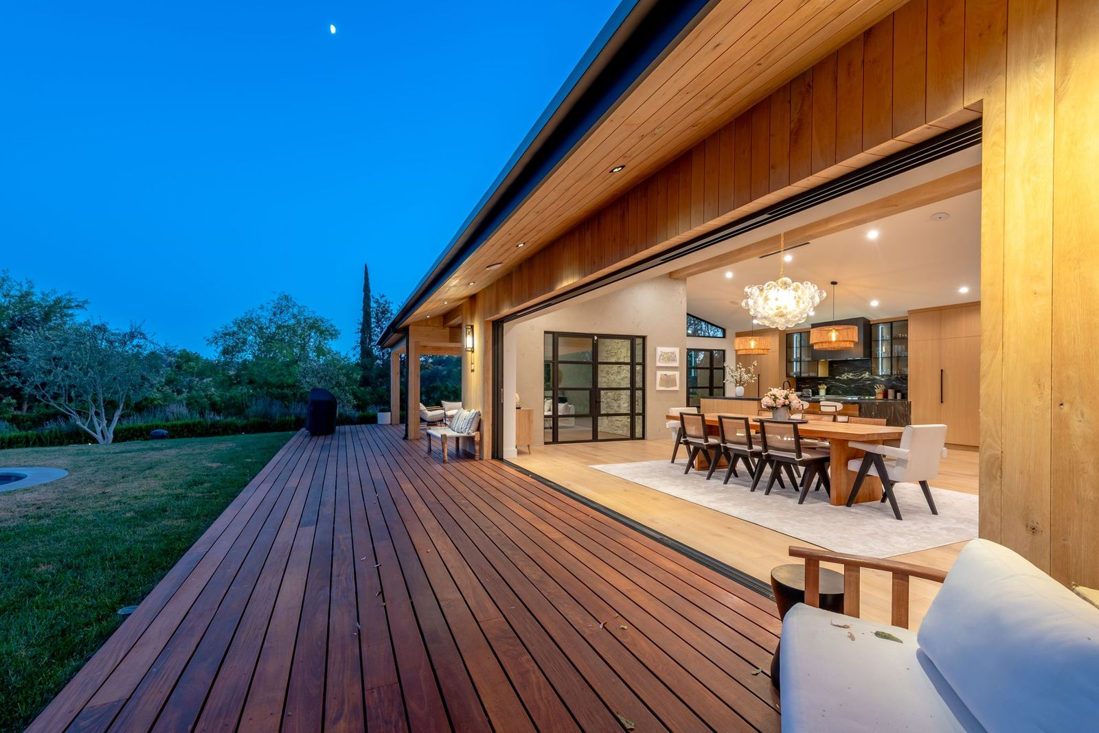 The first is a long open-air wood terrace running the length of the residence, with the Fleetwood doors opening the dining area.
