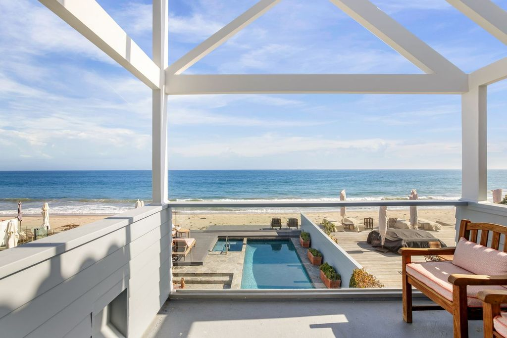Stepping outside, the terrace overlooks the pool, beachfront deck, and ocean.