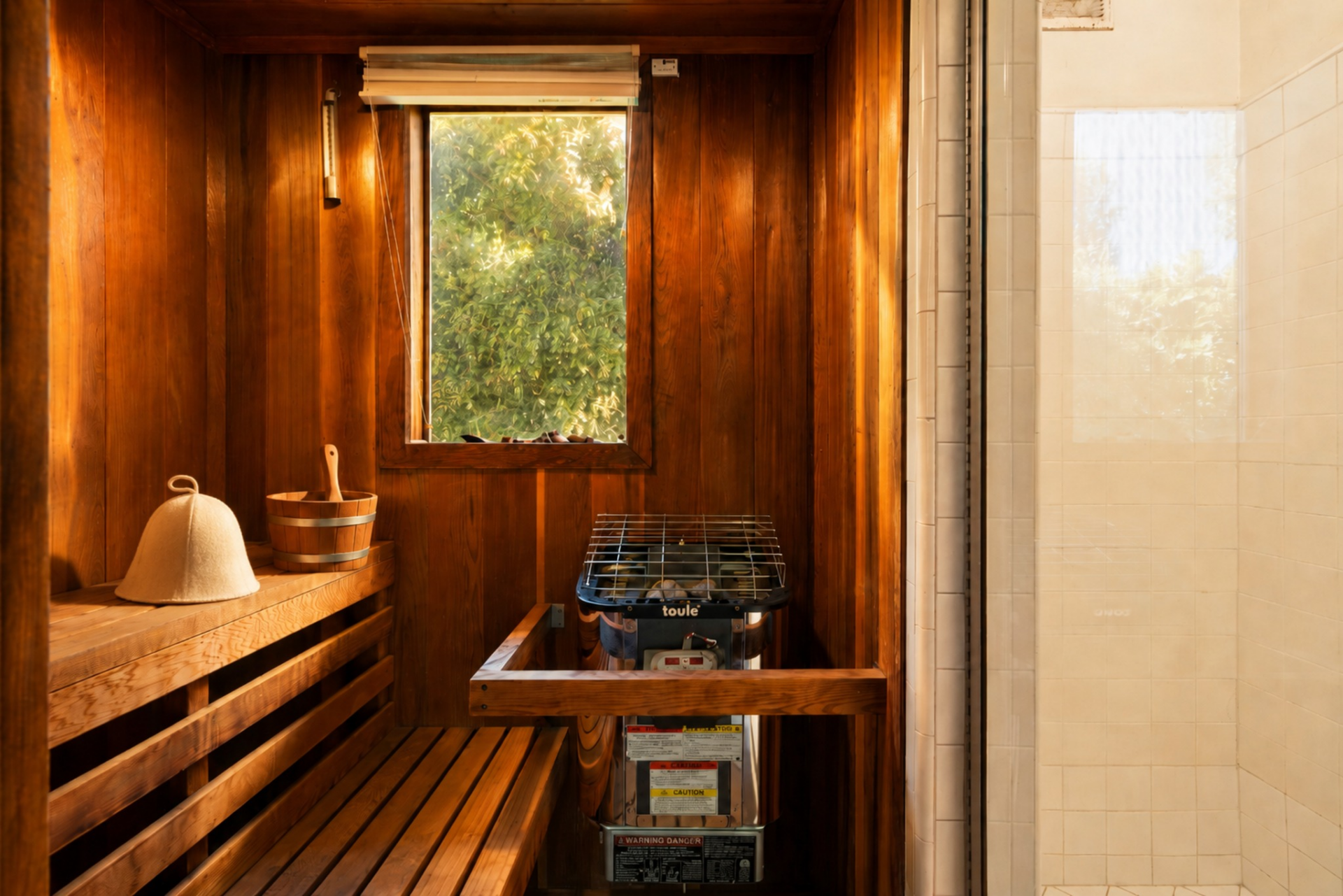 Tucked away beside a shower is a private cedar-lined sauna finished with built-in bench seating and a traditional heater.