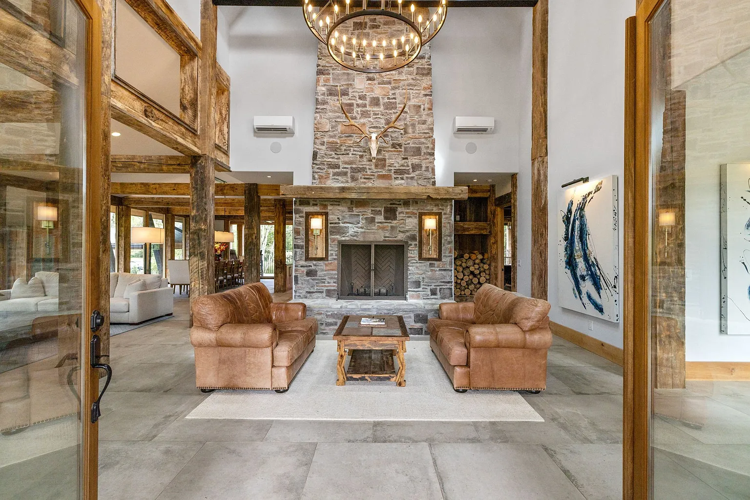 A living room with soaring 35-foot ceiling and a floor-to-ceiling stone fireplace.