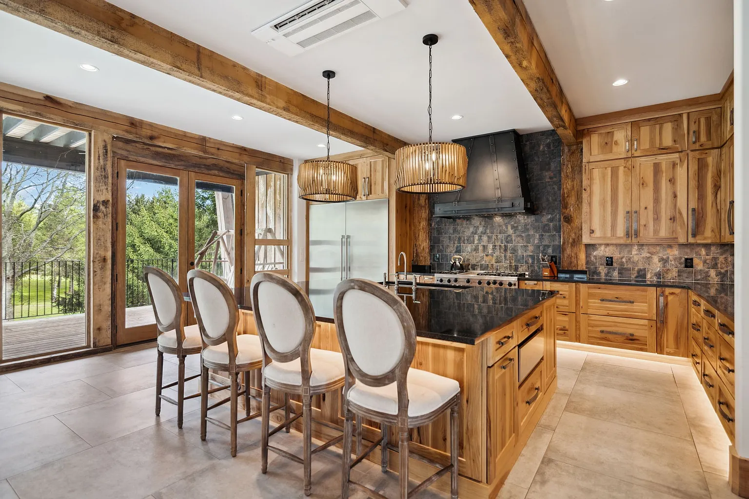 The kitchen features natural wood cabinetry, and dark stone countertops.