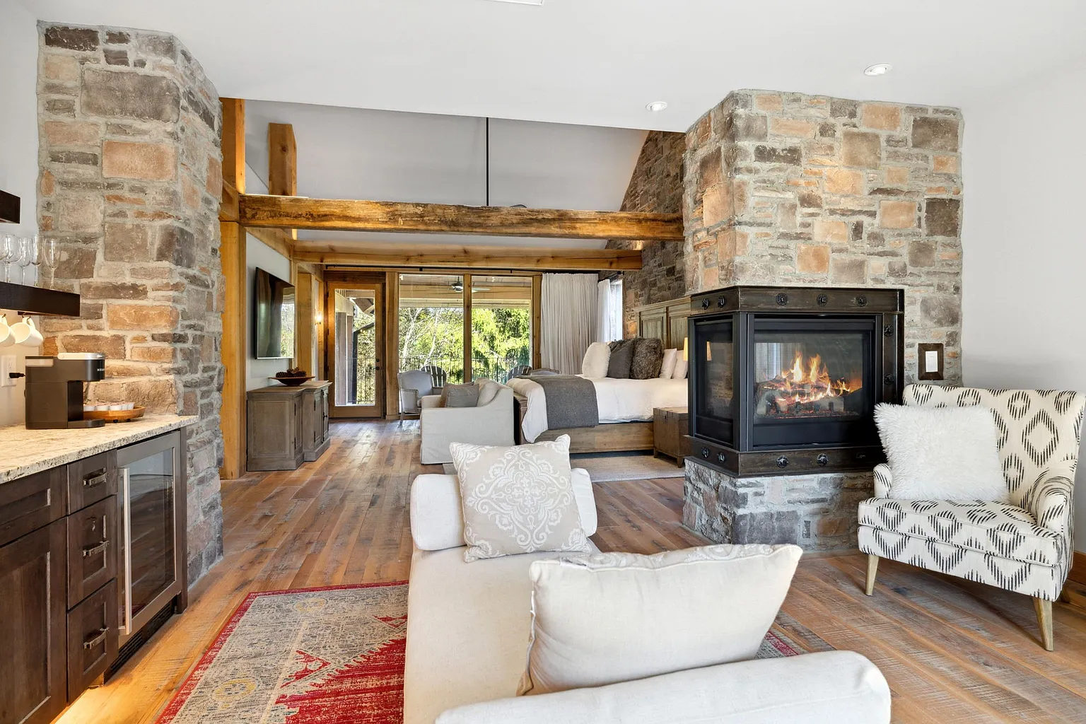 The primary suite is designed as a private apartment within the Manor, combining a spacious bedroom, lounge with a wet bar, fireplace, and private balcony.