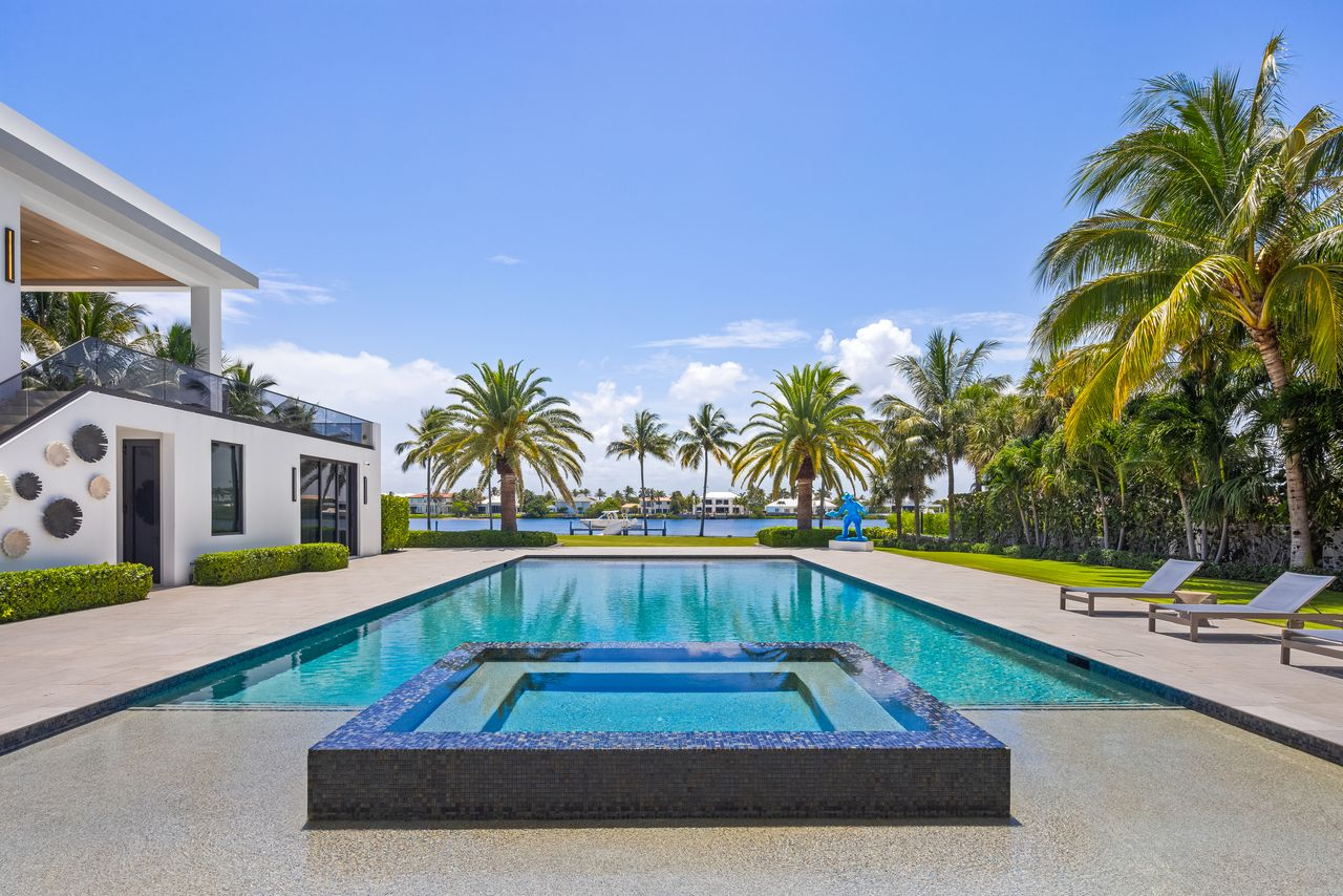 The backyard is centered around a resort-style pool that stretches toward the Intracoastal.