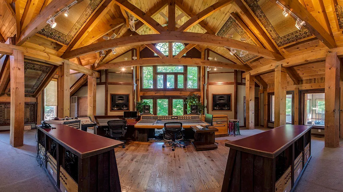 Multiple recording and mixing stations, with dedicated workspaces positioned around the central control desk all with great views of the property's greenery.