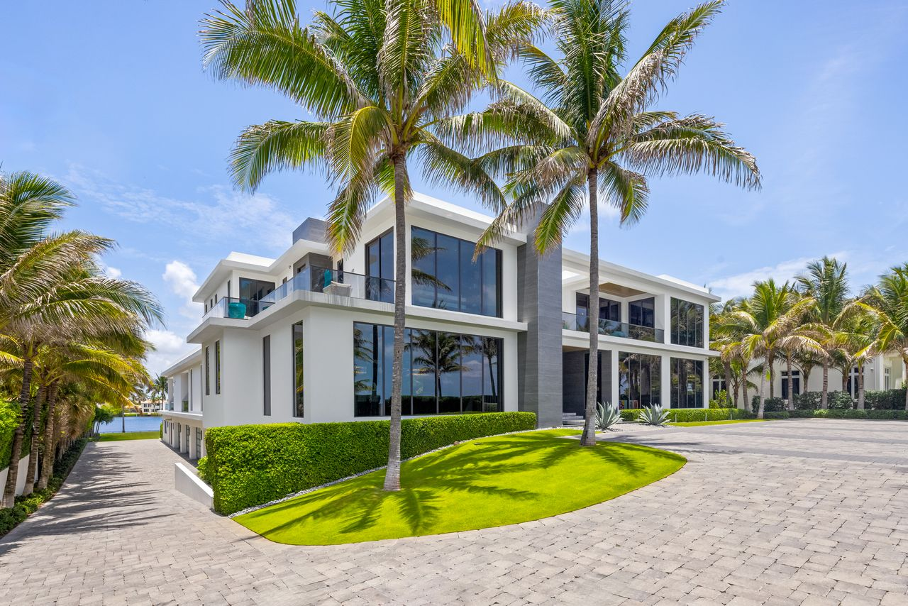 Clean contemporary architecture, crisp white exterior, and a striking vertical stone entry tower.