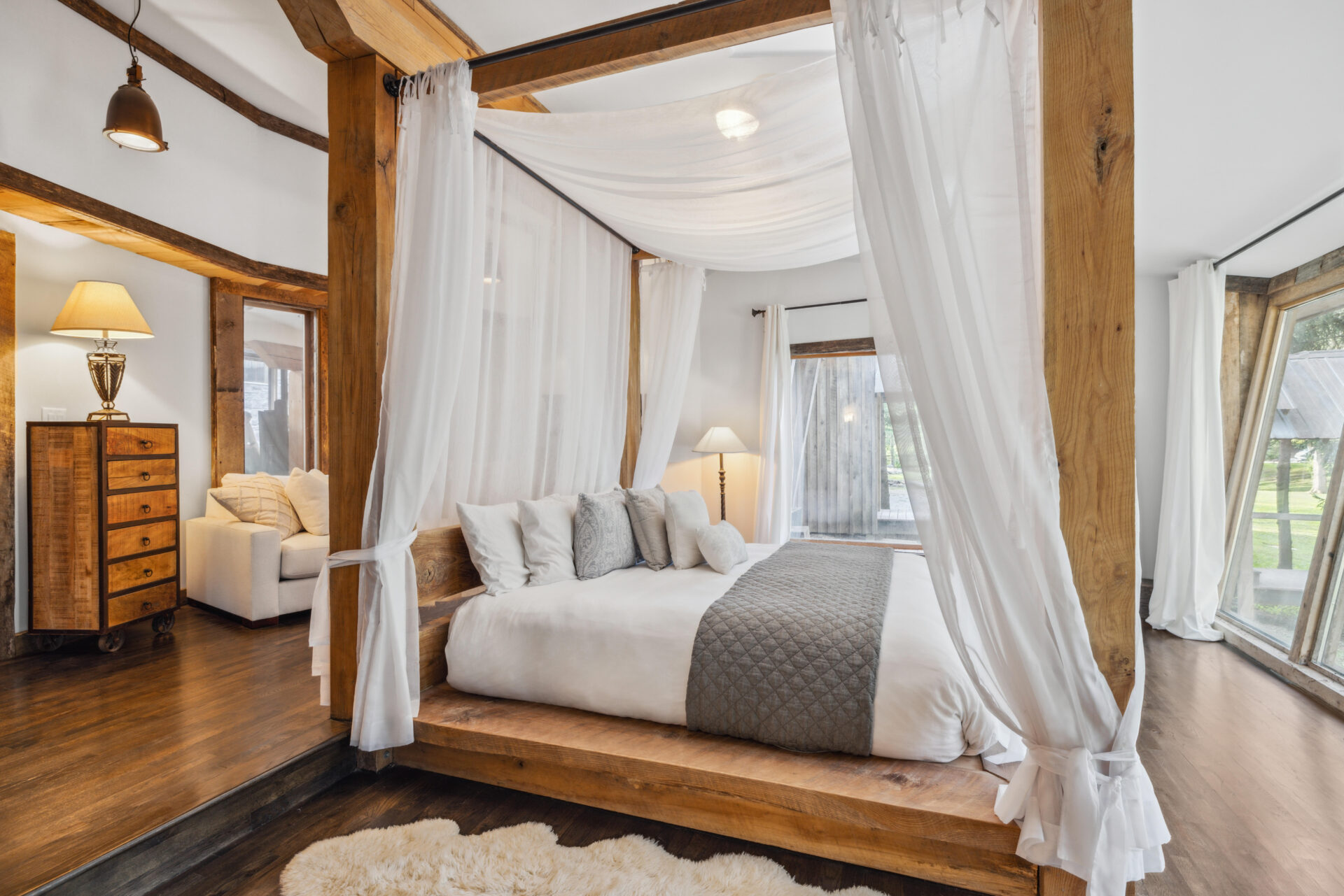 A canopy bed positioned beside oversized windows overlooking the grounds.