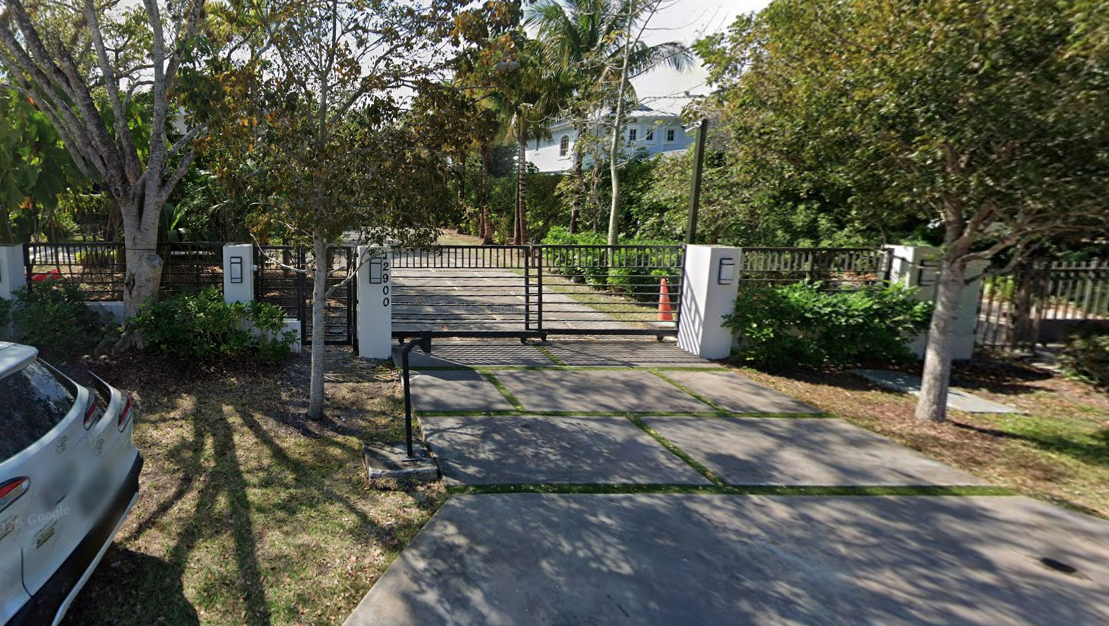 Herro's Pinecrest home can be entered directly from the street, where two sets of metal gates on either side of the property open up to short driveways. 
