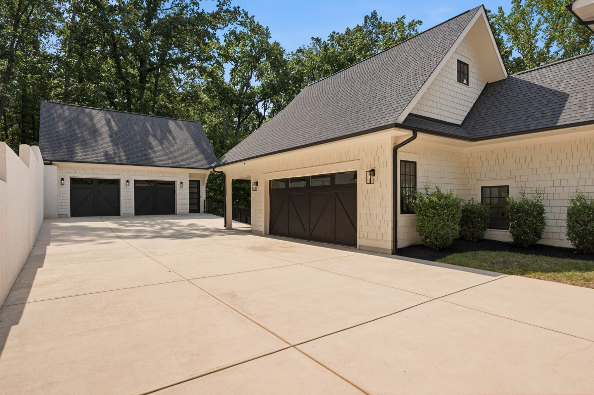 A long motor court connecting the main garage with two additional garage bays in a separate building. 