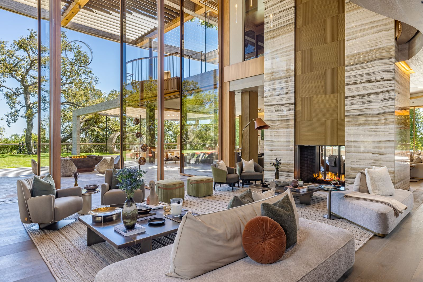 Inside, a tall stone fireplace stands along one side, while multiple seating groups are arranged across the open floor rather than centered around a single focal point.
