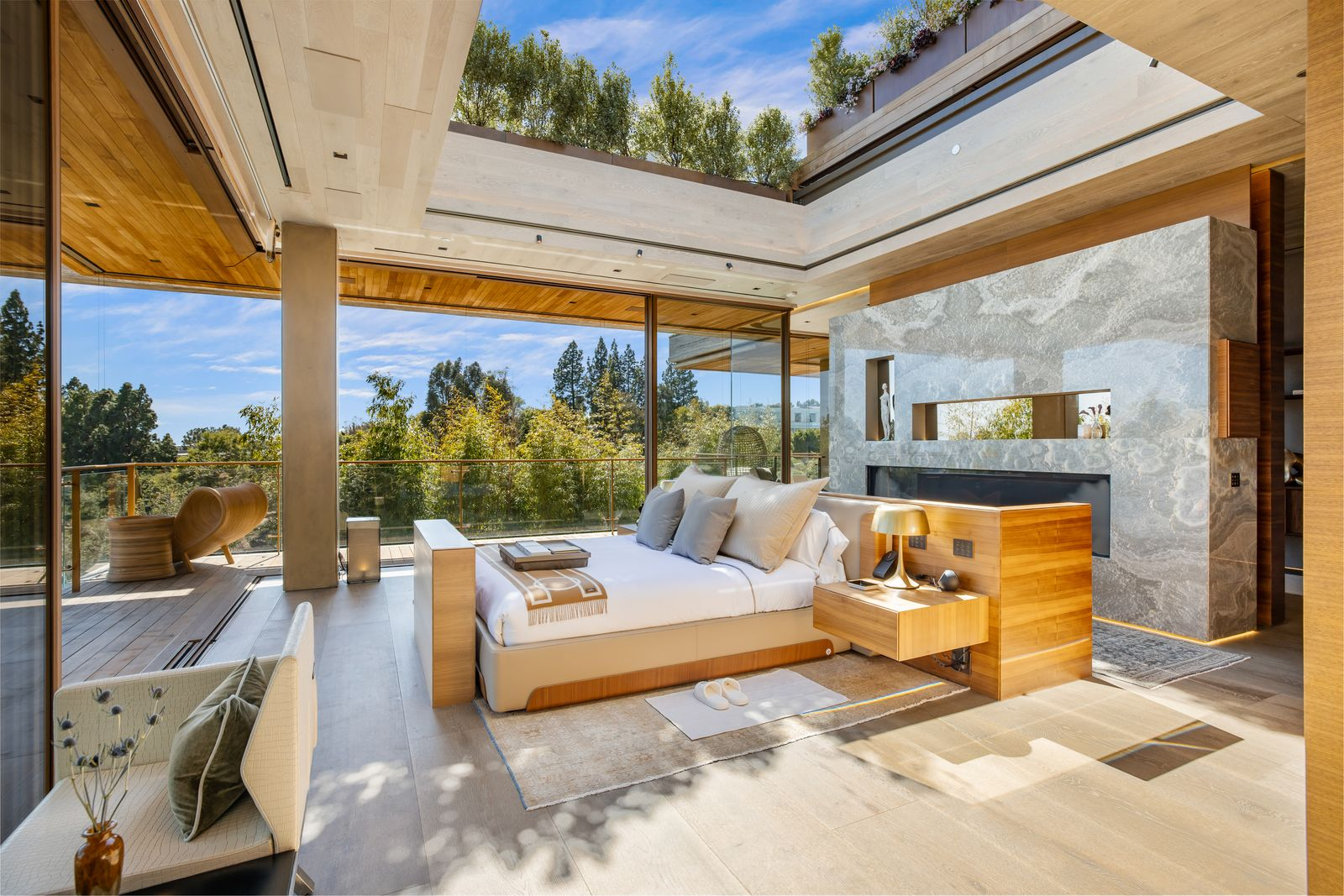 The bedroom is wrapped in glass and centered beneath a retractable roof that opens directly overhead for stargazing.