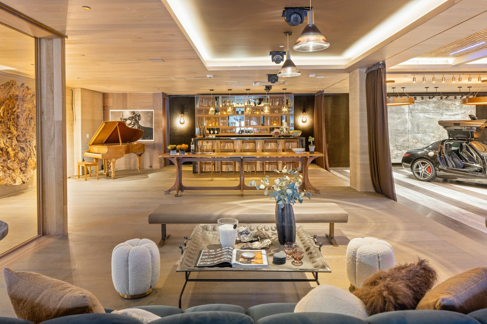 Behind the gallery, the space extends into a jazz club with a bar, grand piano, and additional seating.