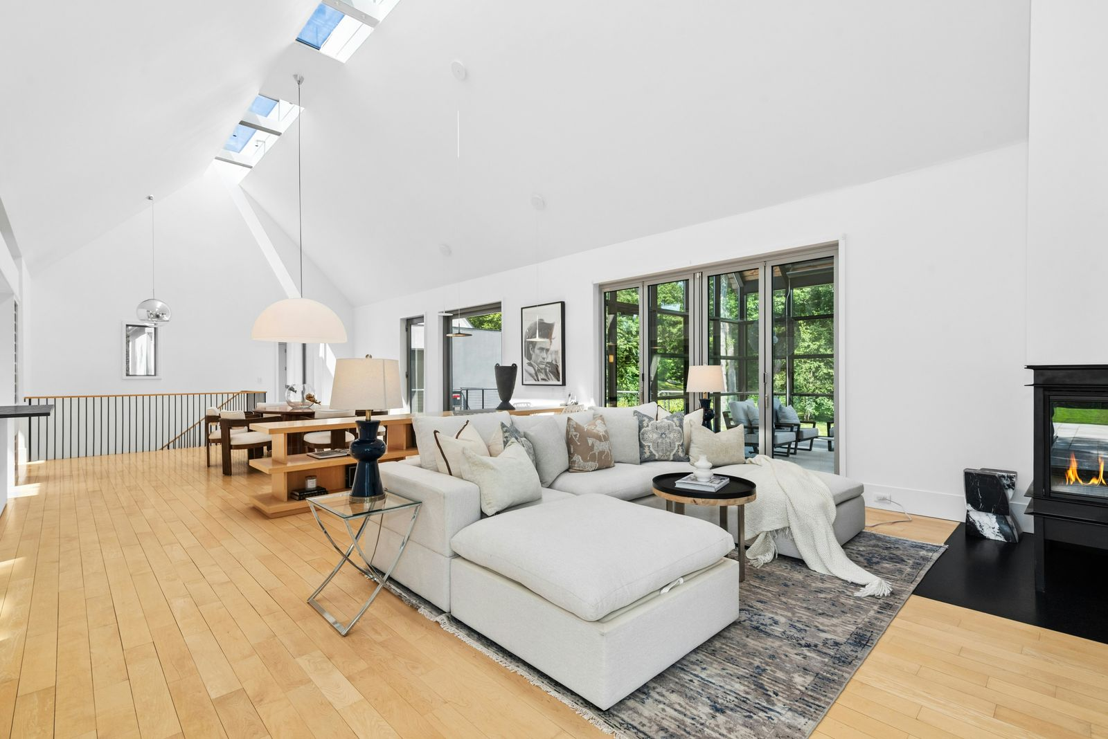 A family room with a U-shaped sectional facing a television and another fireplace in the corner.