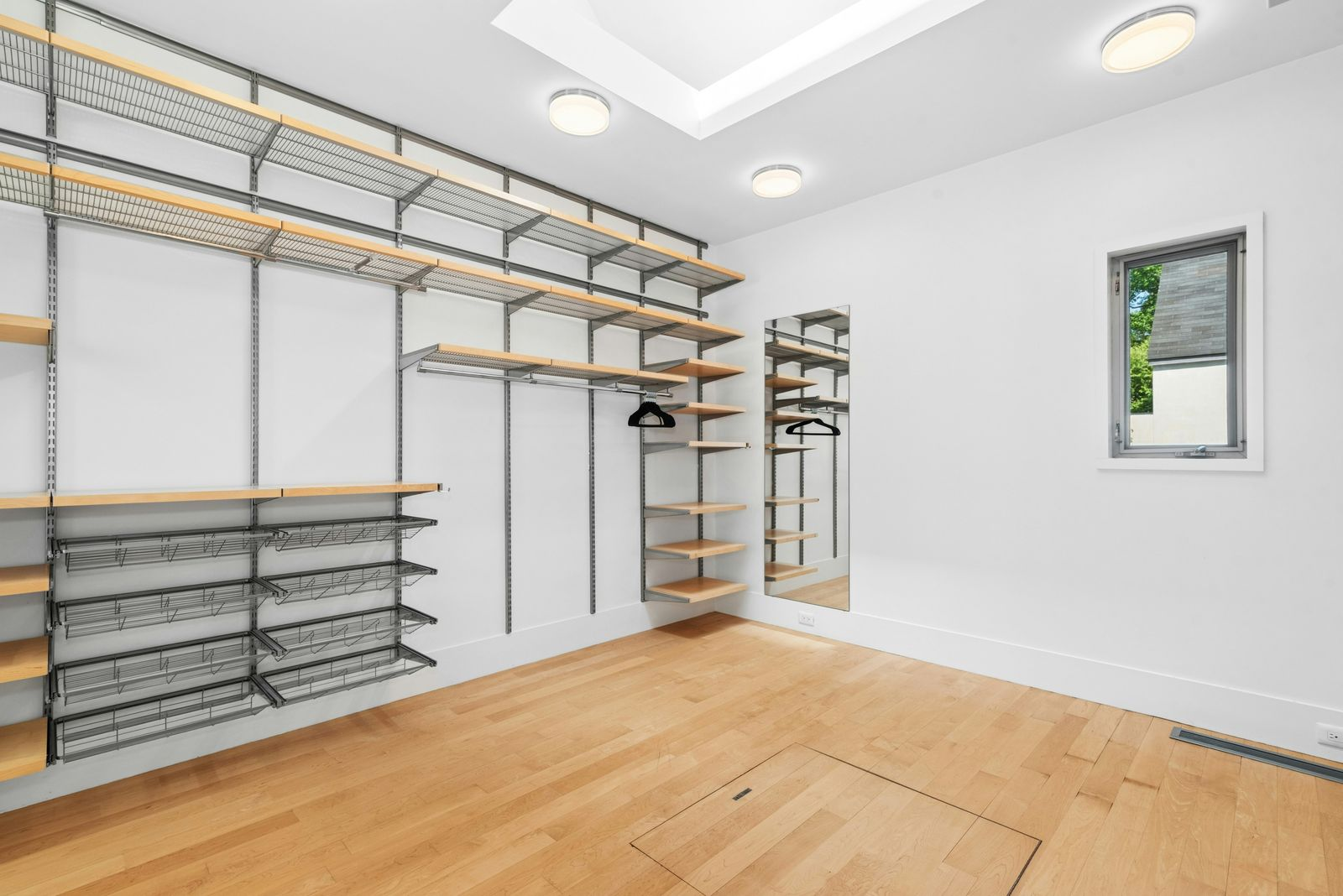 A large walk-in closet lined with open shelving, hanging rails, and shoe storage.