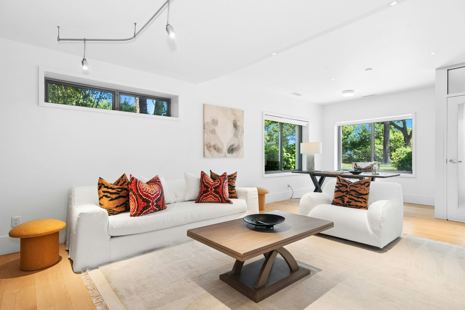 A comfortable sitting room, with a white sofa and armchair gathered around a low wood coffee table.