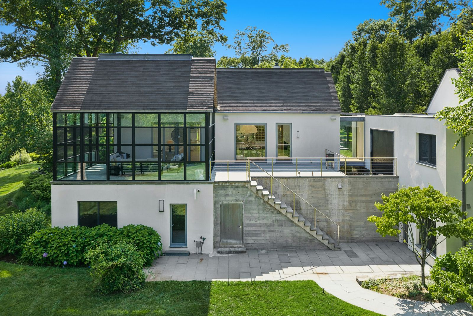 Beyond the glass, the room opens directly onto an expansive terrace overlooking one of the estate’s two cascading waterfalls and the koi sanctuary below.
