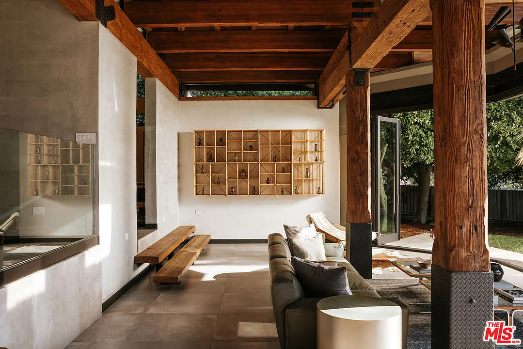 The main living room occupies a slightly sunken portion of the floor plan, separated from the upper level by a glass railing.