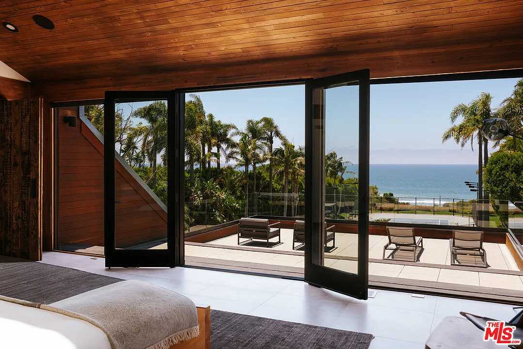 The terrace runs along the outer edge of the bedroom with unobstructed views across the lawn and out toward the ocean.