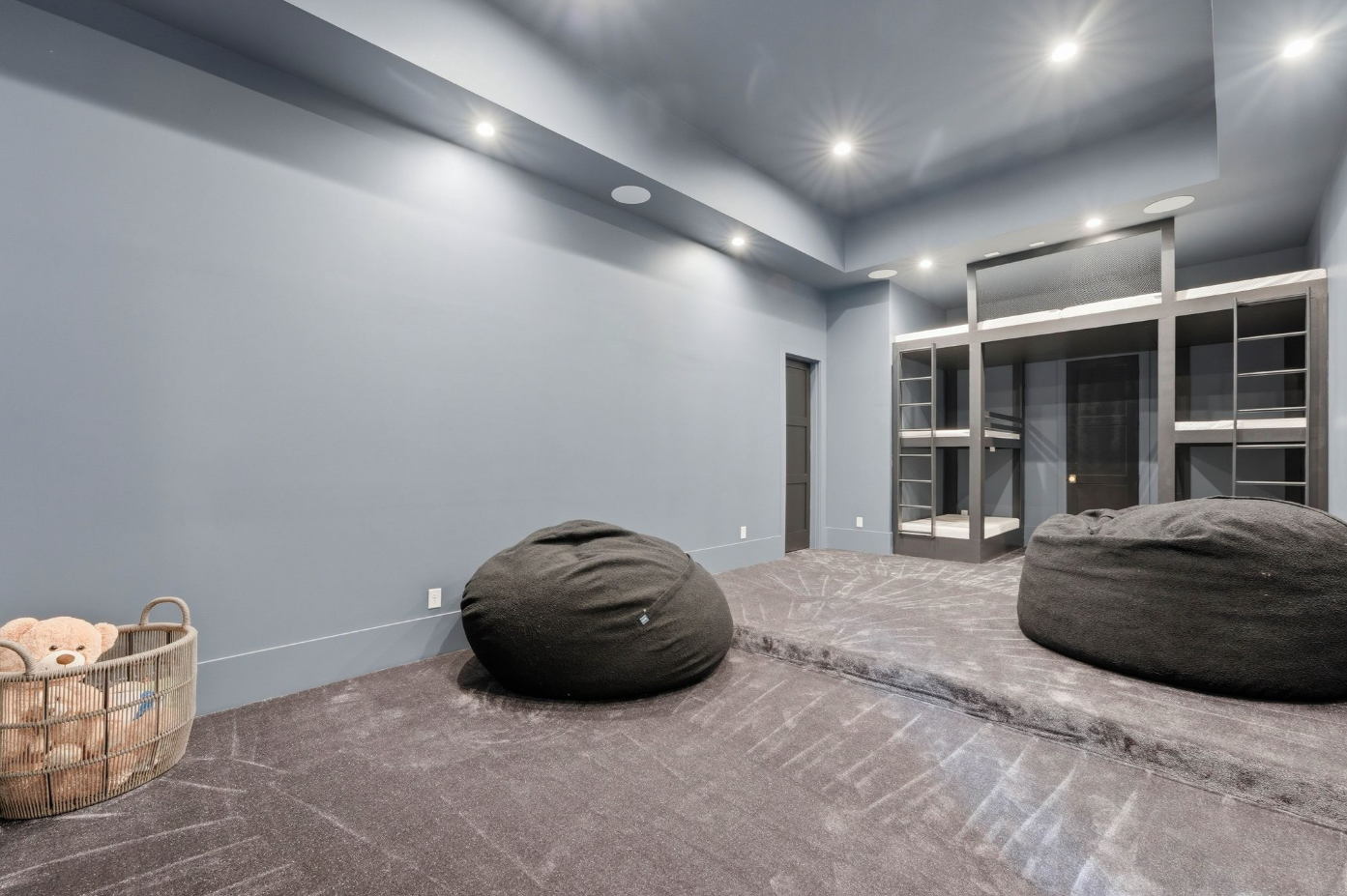 The theater-ready room is finished in deep gray tones with tiered carpeting already configured for two levels of seating. 
