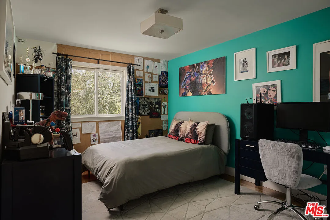 One of the children’s rooms has a more expressive personality with the bed sitting against a saturated teal feature wall lined with framed artwork.