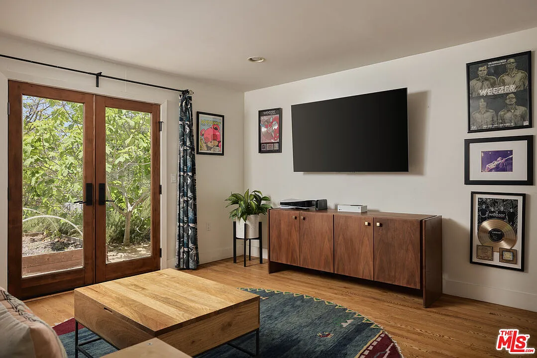French doors open directly to the landscaped hillside, while framed Weezer memorabilia, including concert posters and a record plaque, gives the room a more personal connection to Shriner’s career.