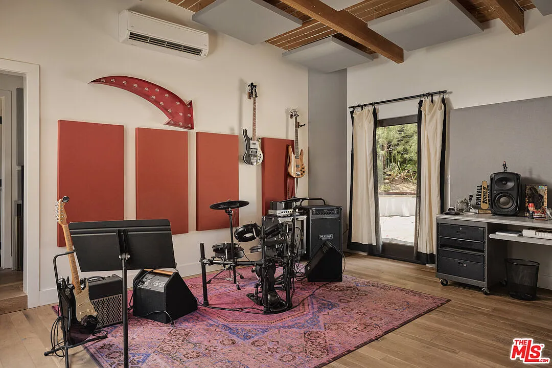 The music studio has exposed ceiling beams fitted with acoustic panels and additional sound treatments lining the walls.