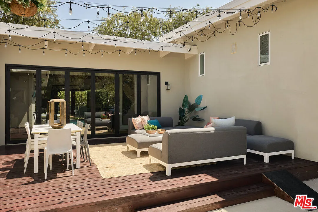 Outdoor deck divided between a dining table for outdoor meals and a larger lounge for soaking up the sun.