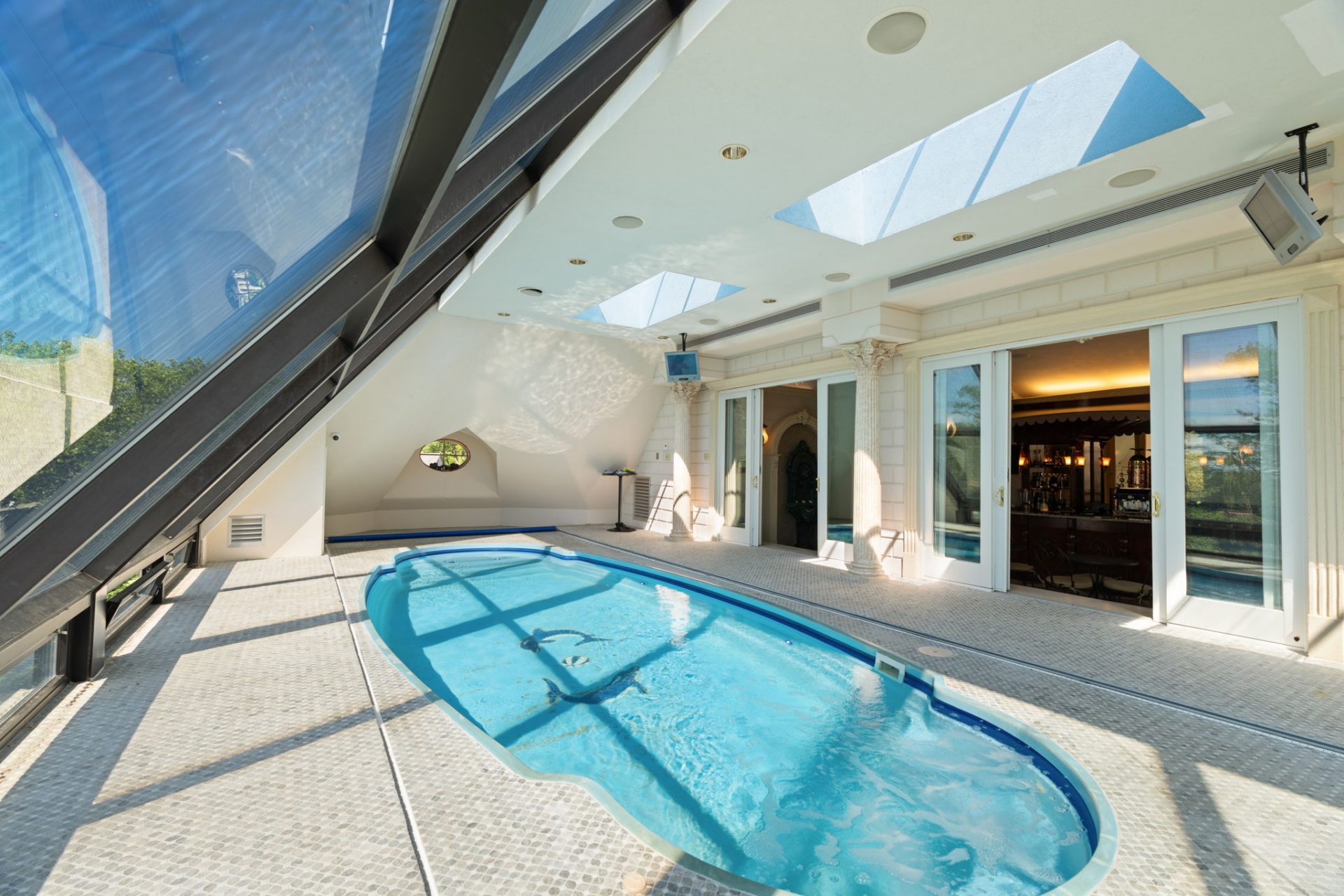 Doors directly off the café lead to the indoor heated swimming pool sitting beneath skylights and beside a sloped wall of glass.