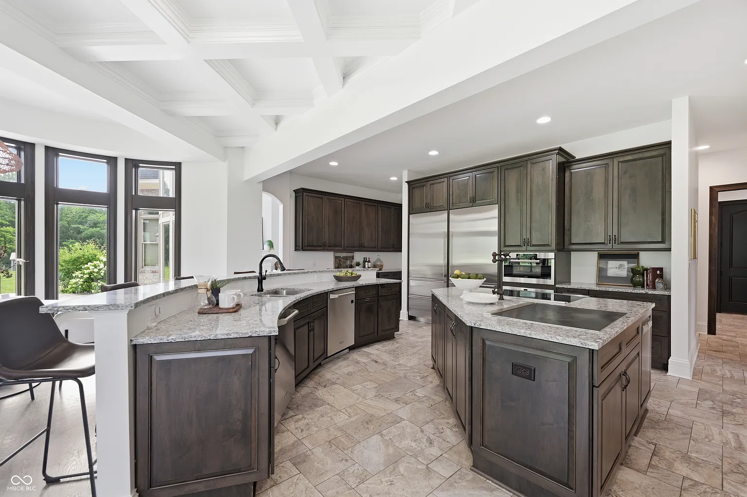 The kitchen opens to an oversized center island with a professional-style cooktop and additional storage underneath. 