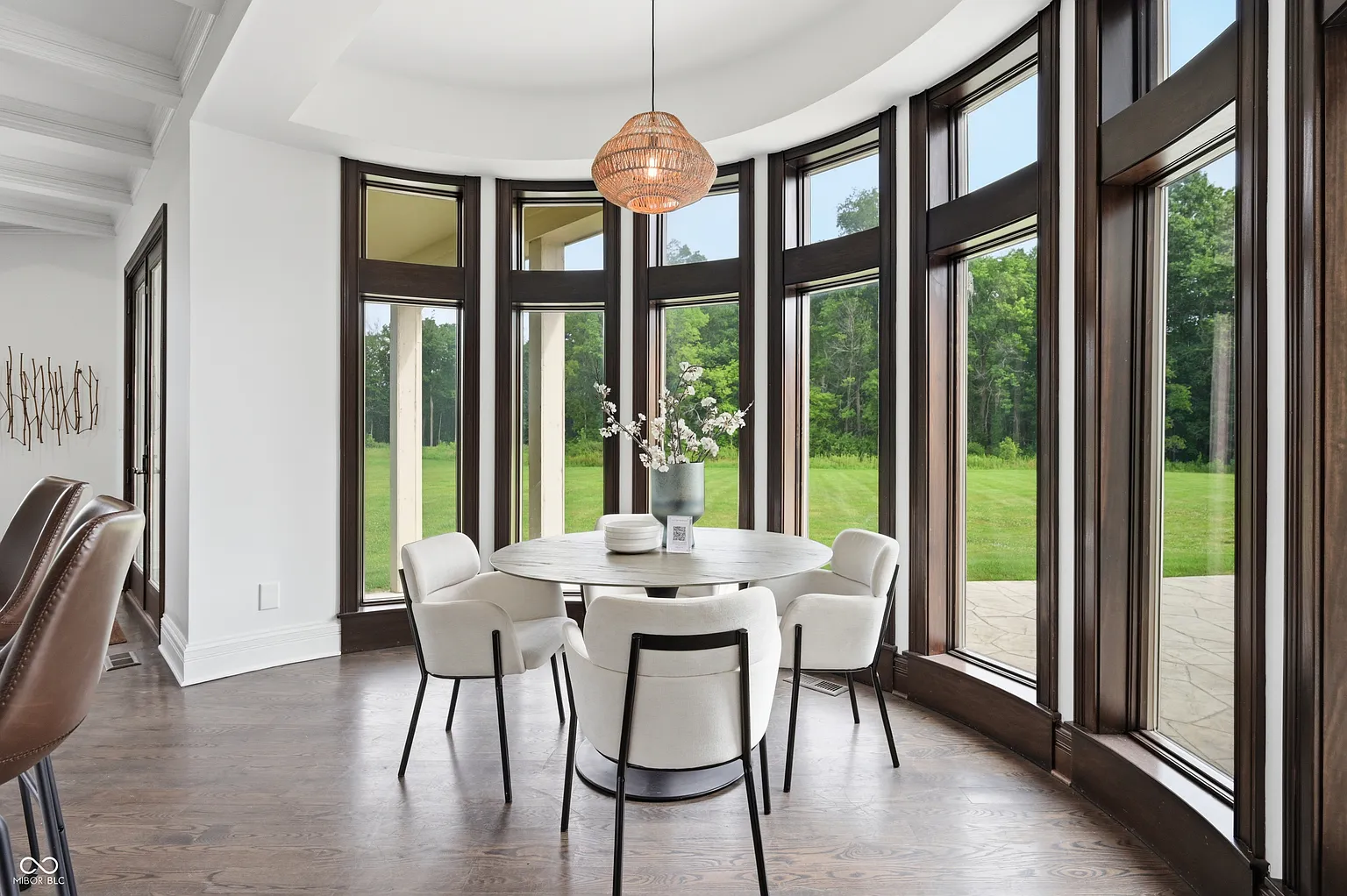 A curved breakfast nook where the stone flooring transitions to wood beneath a round dining table.
