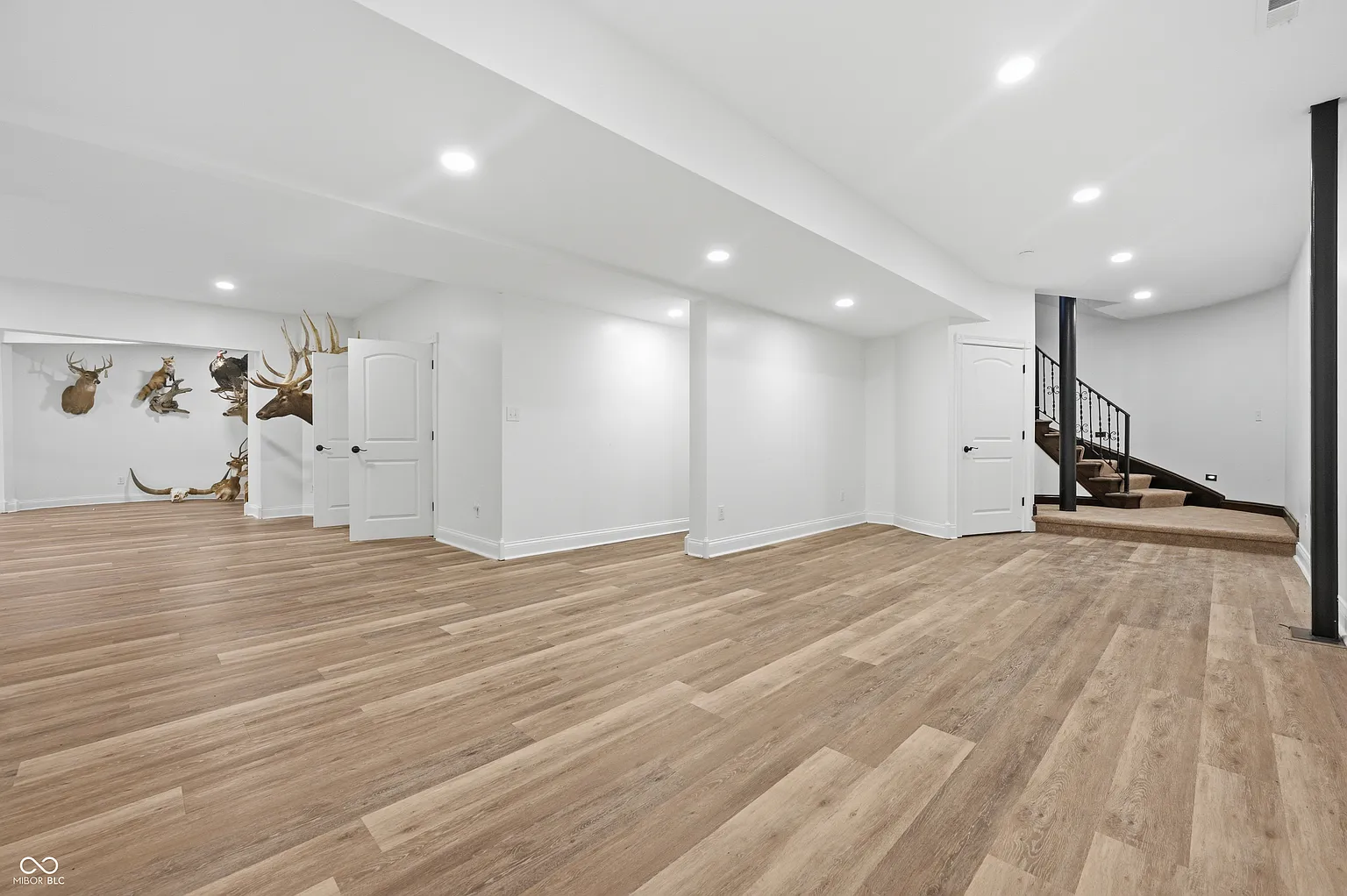 Down the stairs, the lower level opens into a large recreation room with long stretches of open floor space that can be furnished with multiple seating areas or game tables. 