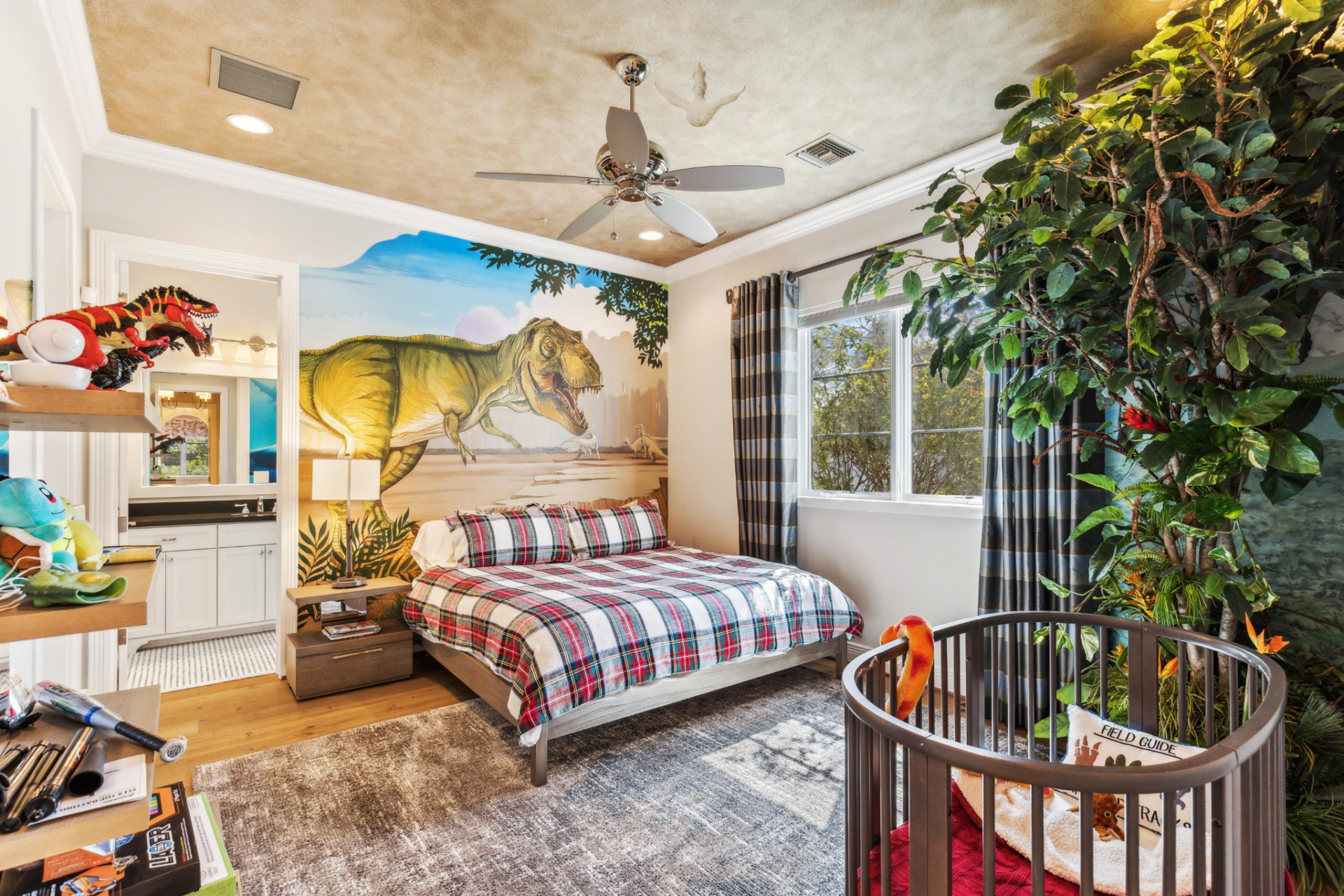 The boys’ bedroom has a much more playful design, built around a full-wall dinosaur mural behind the bed. 