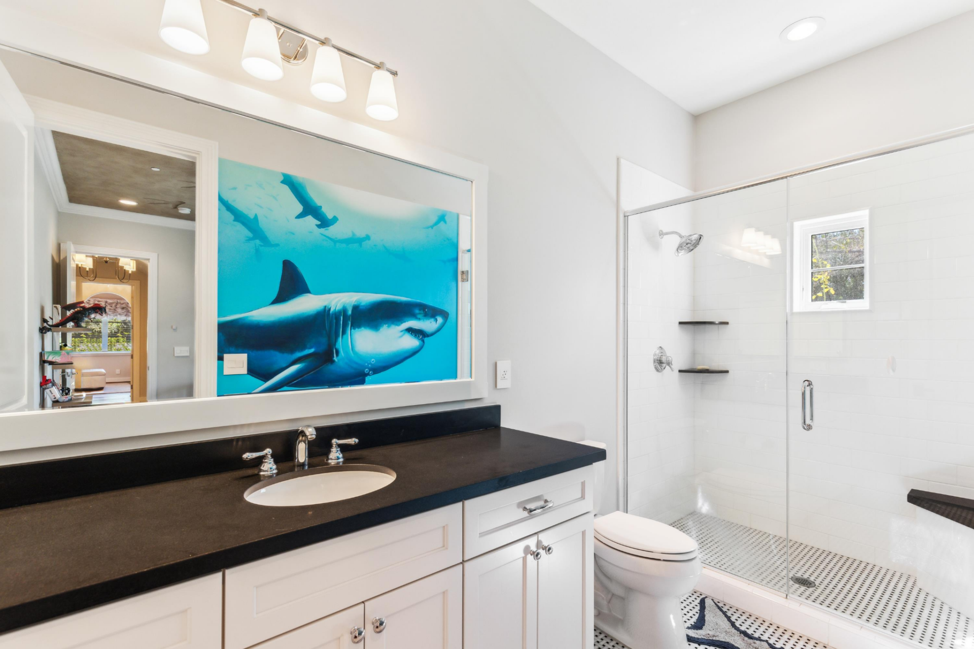 The bathroom continues the adventurous theme with a large shark mural visible in the mirror's reflection. 