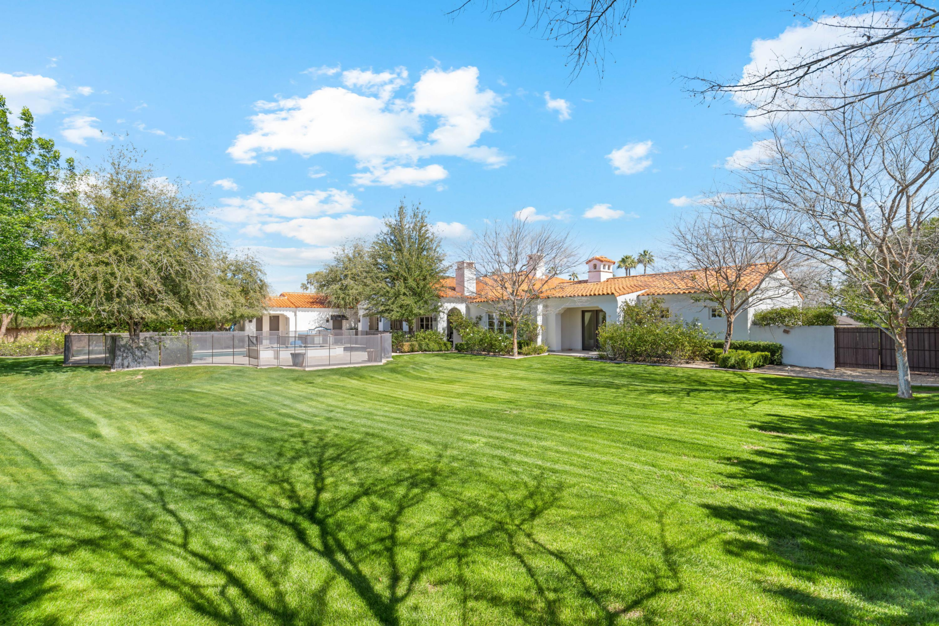 Beyond the pool, the yard opens into a large level lawn that stretches across the rest of the property.