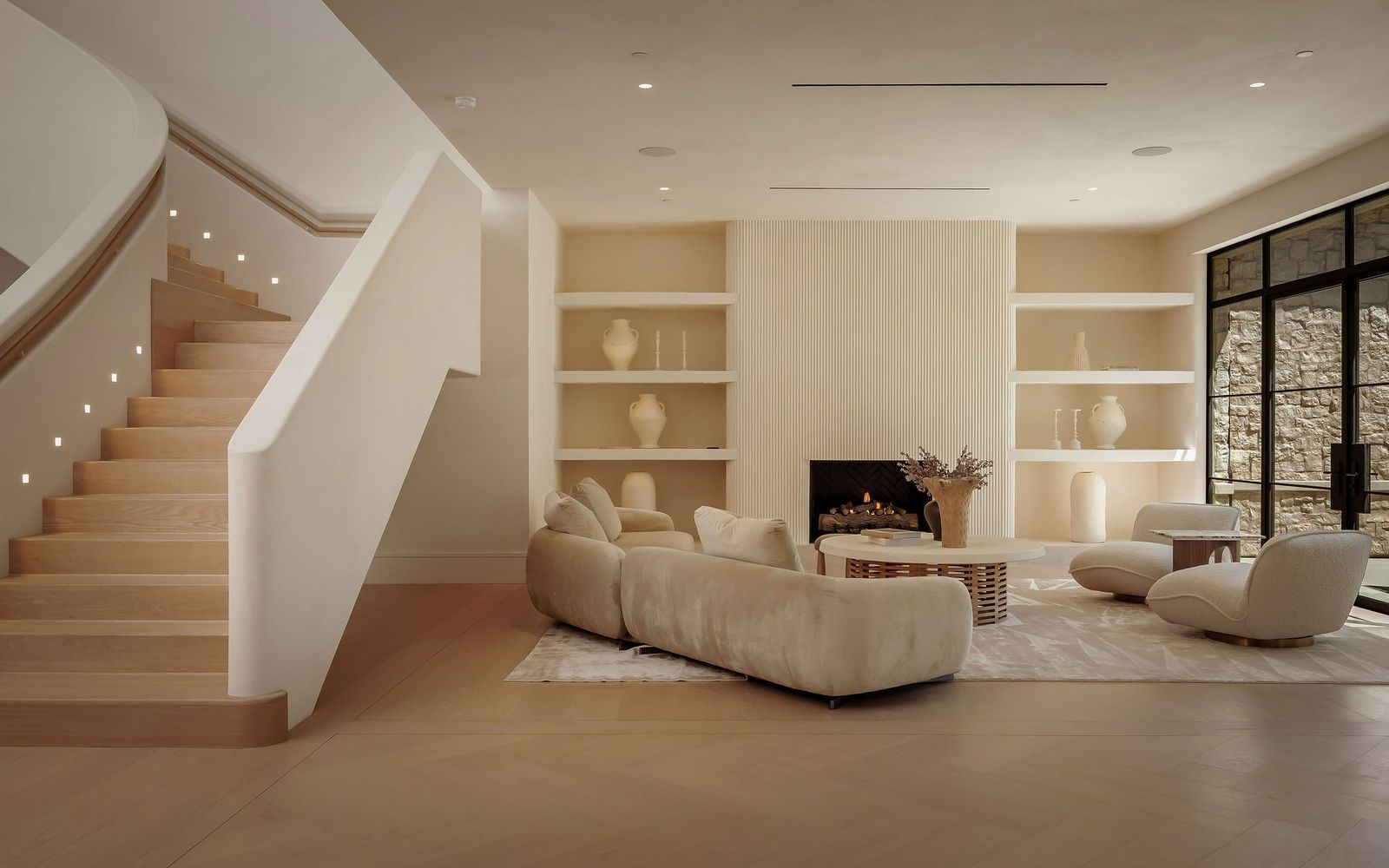 a front sitting room is arranged around a fireplace set into a vertically ribbed plaster surround, with built-in display shelves built into the wall on either side. .