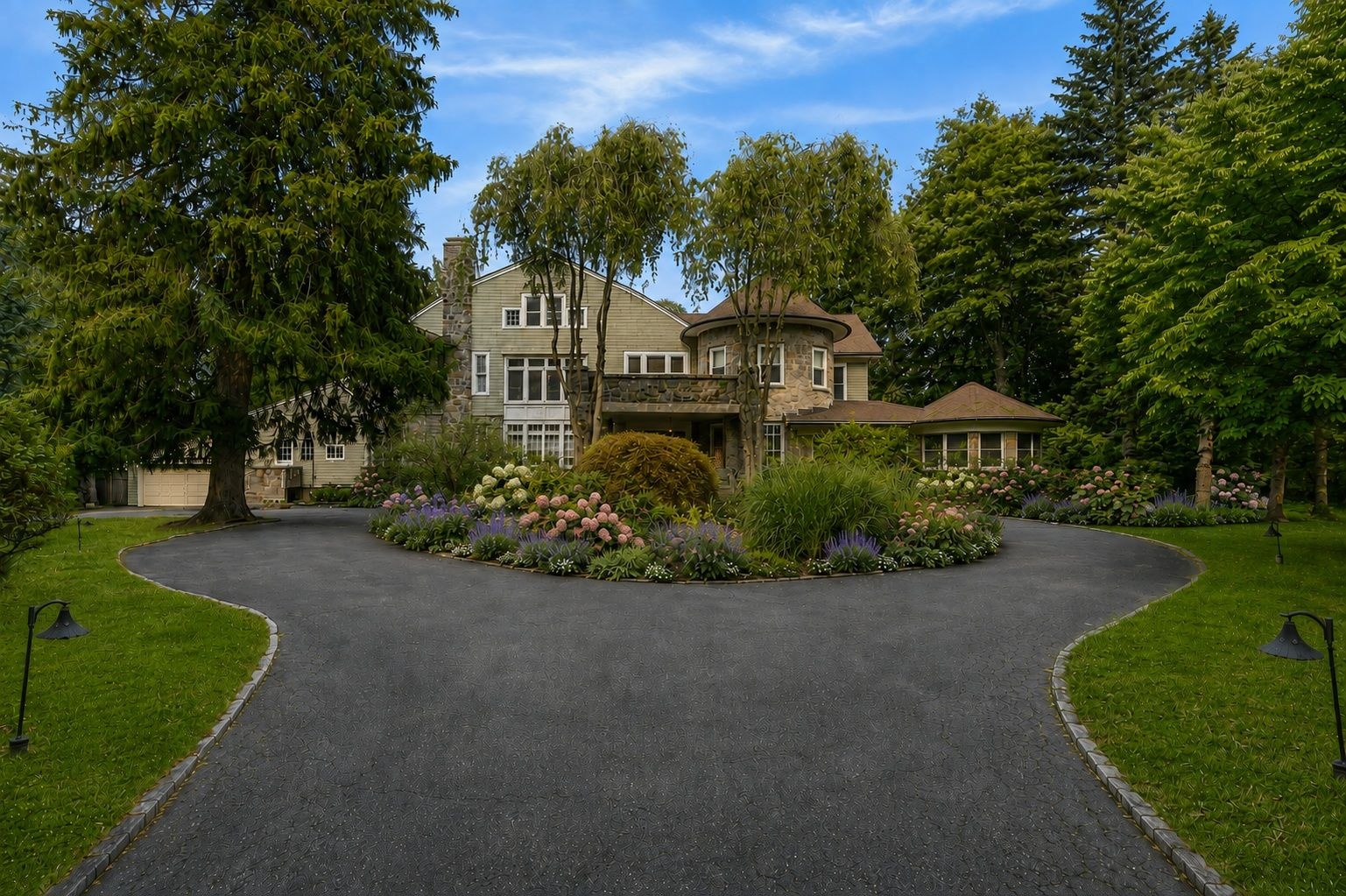 A circular driveway sweeps around a densely planted center garden before reaching the front of the house.