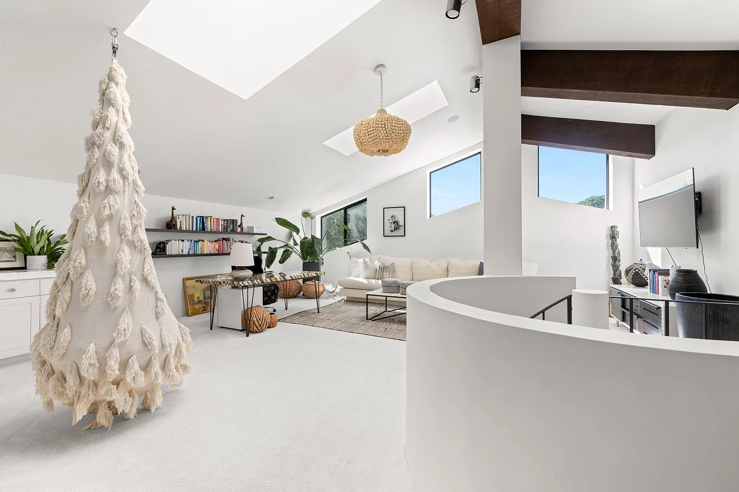 The office is furnished with a sitting area, desk, and office space on one side and a suspended chair on the other near the open railing.