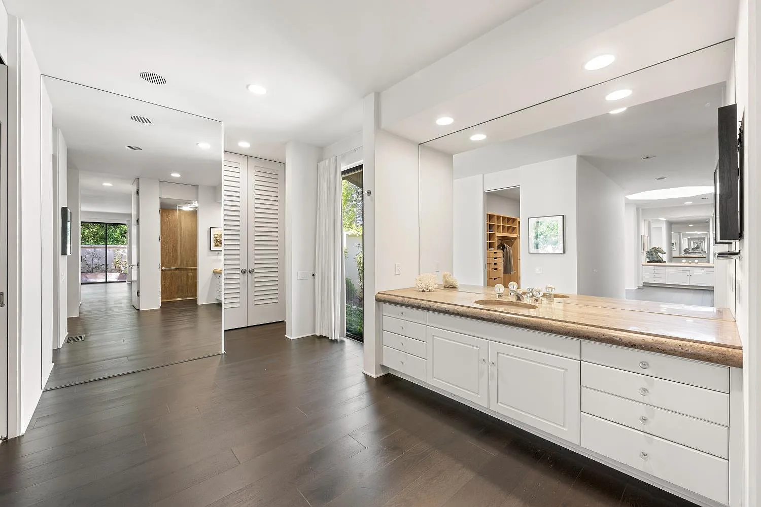 The bathroom is divided into two separate sides, giving each person their own vanity area, shower, toilet, and walk-in closet.