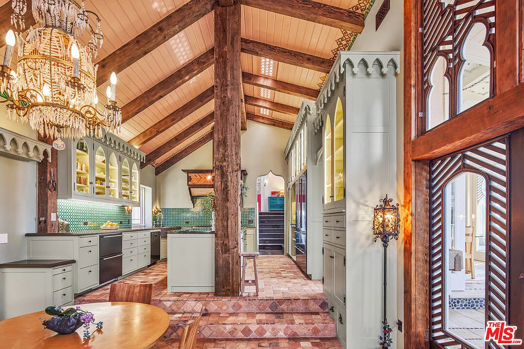 The island provides a second prep and gathering area before the floor steps down into the breakfast nook.