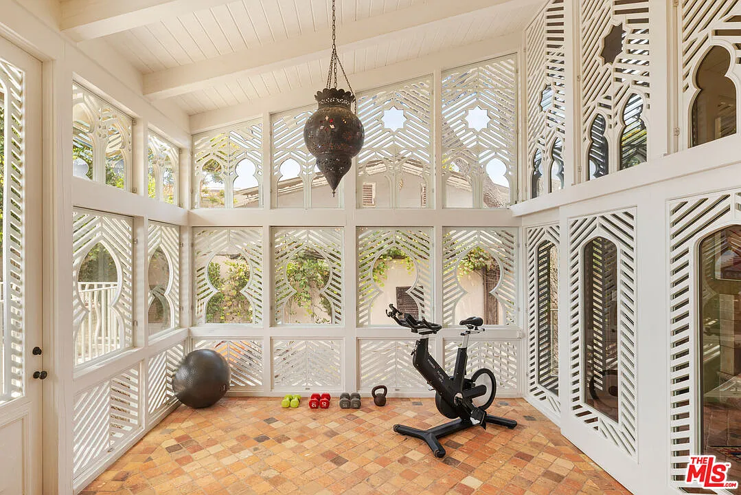 A bright sunroom is wrapped almost entirely in the home's geometric windows.
