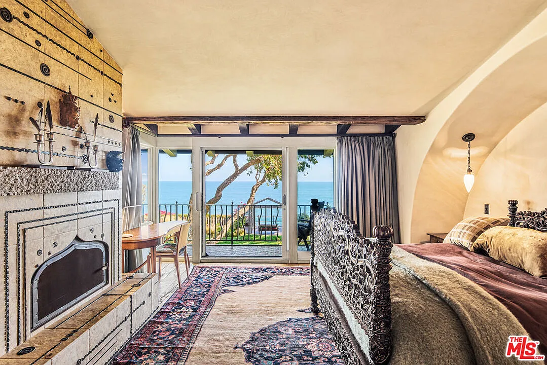 A carved bed sits right across from a fireplace. 