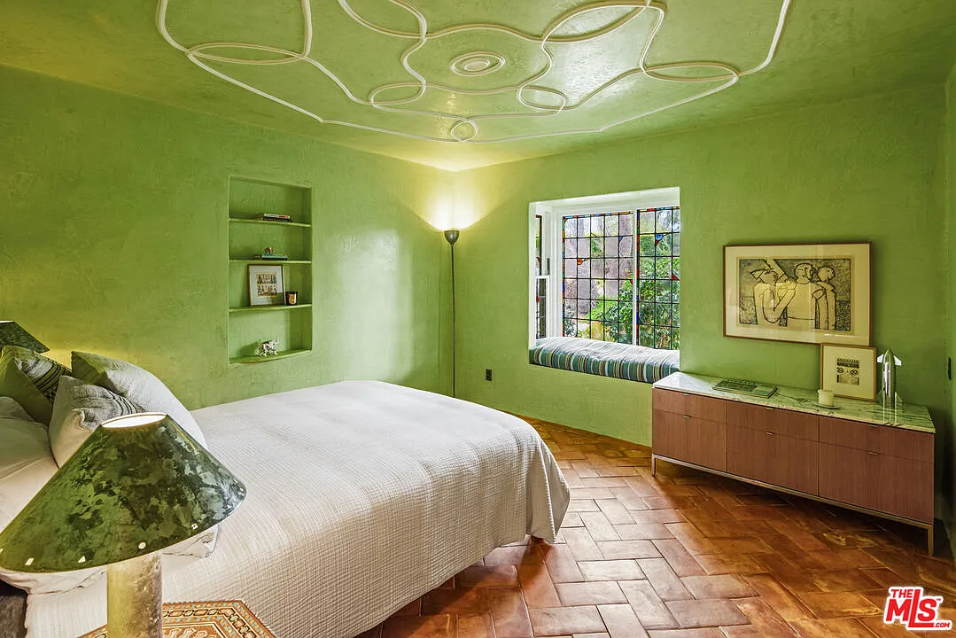 The second bedroom is painted entirely in lime-green with only terracotta flooring creating a break in the color. 
