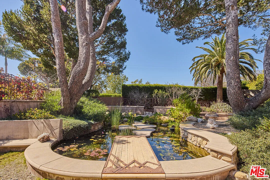 A lily pond edged with stone and curved concrete seating. 