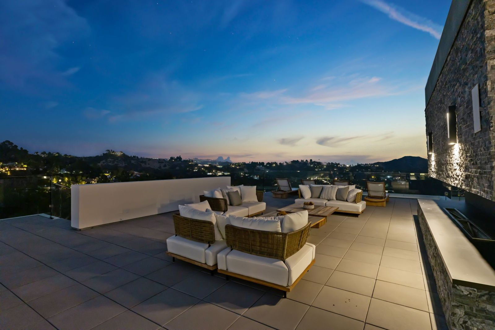 Above the grounds, the rooftop deck creates another large gathering area overlooking the pool, surrounding hills, and distant city skyline. 