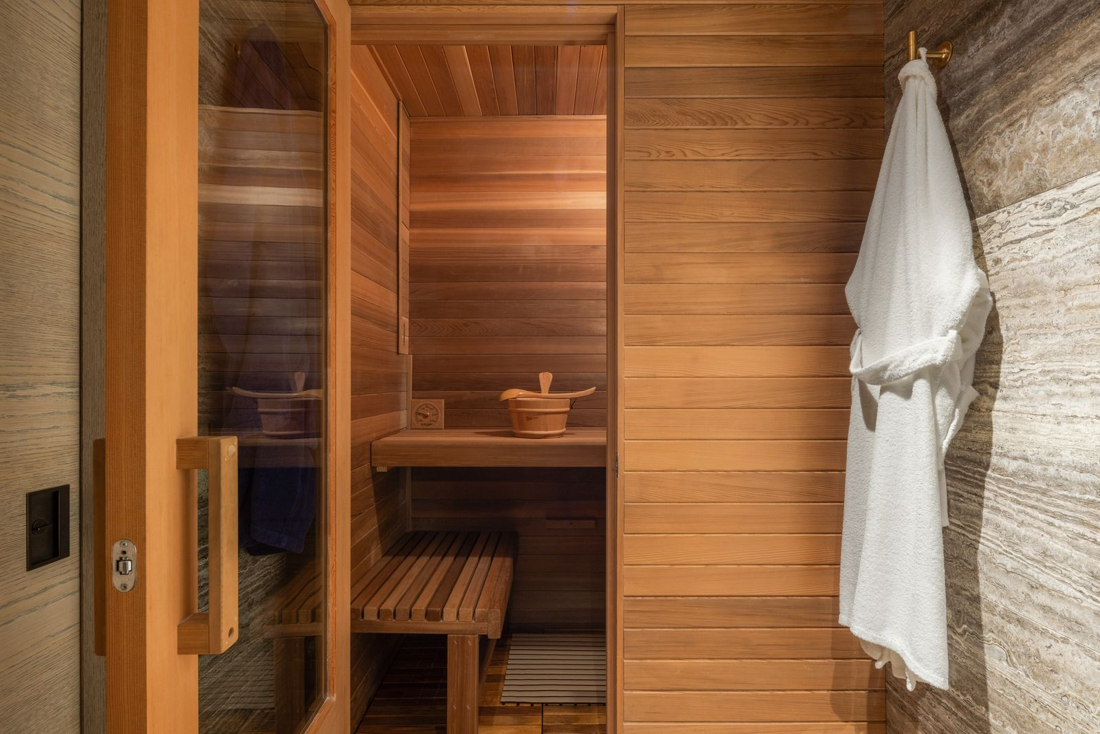 Completing the layout is a cedar-lined sauna positioned just beyond the bathroom, creating a private wellness area within the suite.