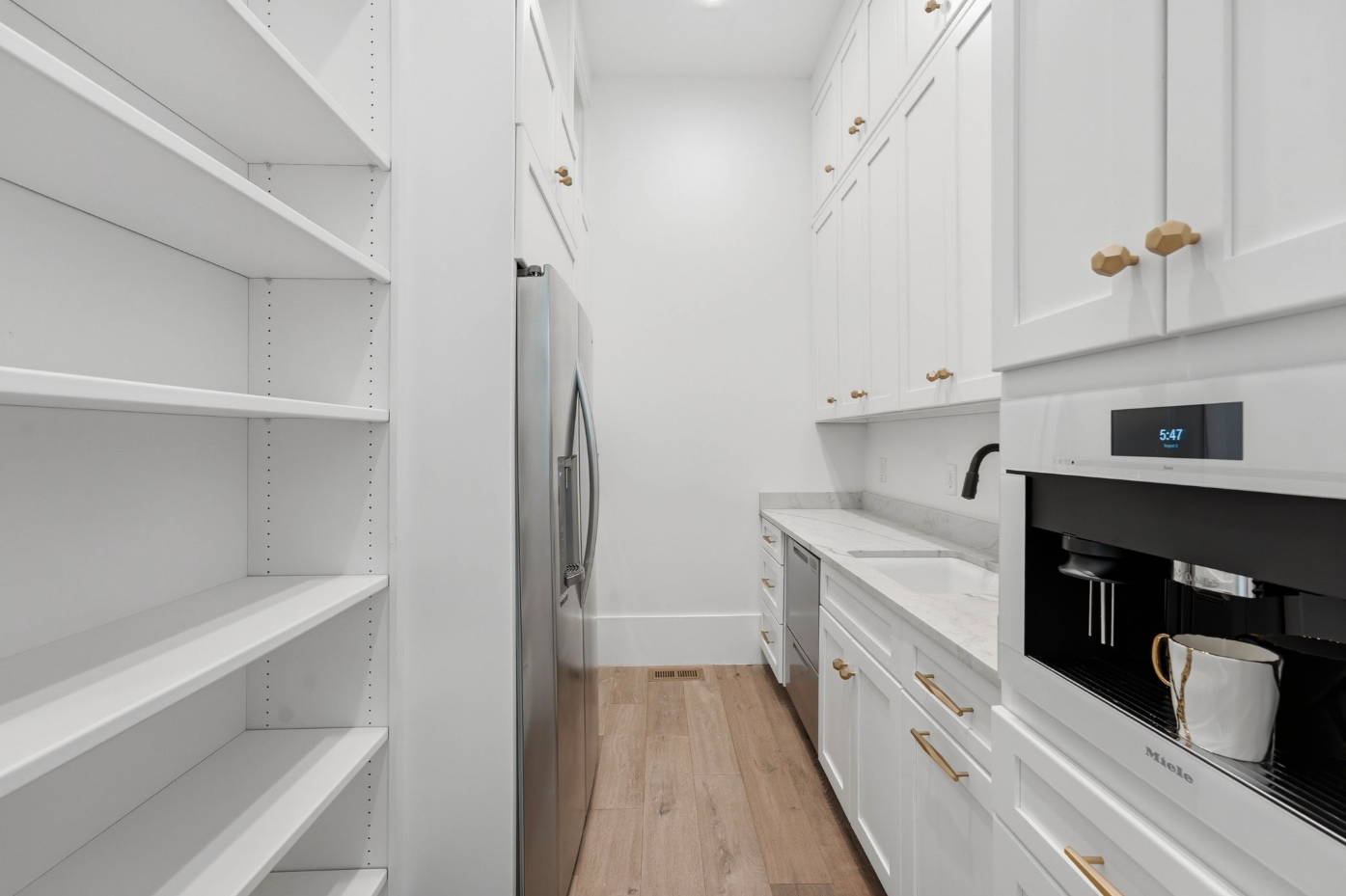 A fully equipped scullery adds a second sink, additional refrigeration, open shelving, and floor-to-ceiling storage.