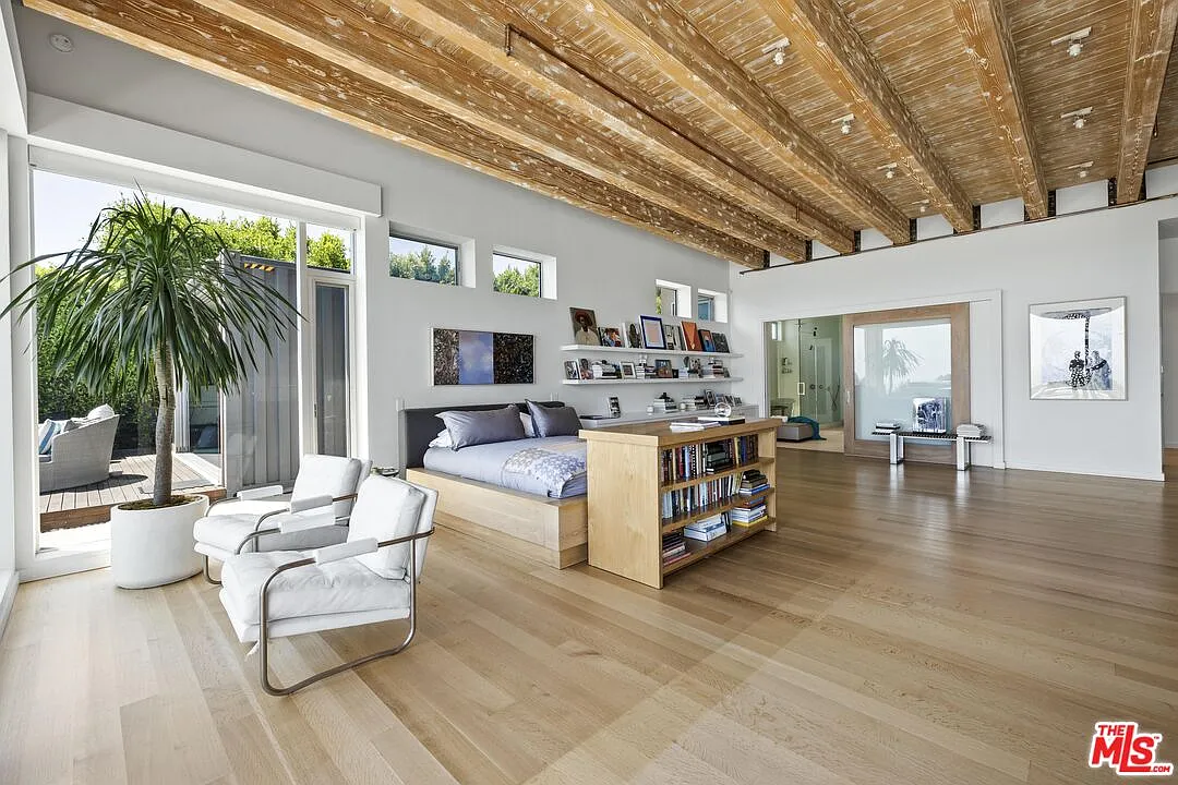 A low bookcase in front of the bed helps define the sleeping area without interrupting the room’s open views toward the ocean.