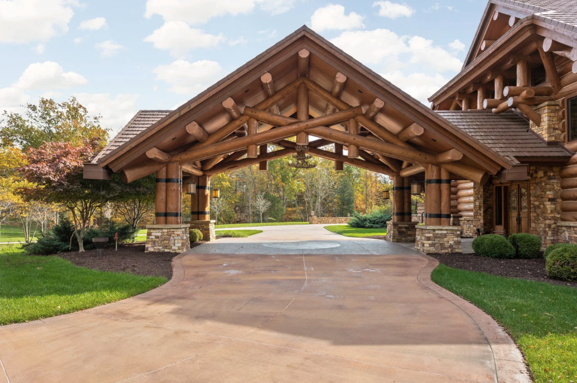 Main house's covered entry, bringing you alongside the lodge-style exterior built from lodgepole pine sourced from the Northern Rockies and layered with stonework.
